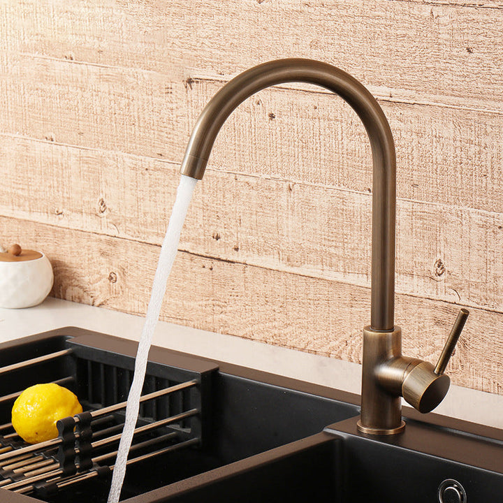 Antieke messing keukenkraan met stromend water in een moderne spoelbak