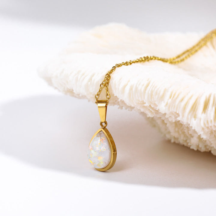 Chique gouden ketting met natuurlijke opaal druppelhanger. Luxe damesaccessoire.