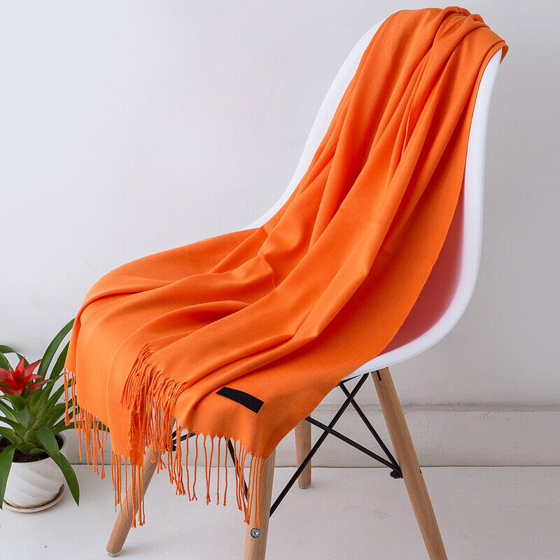Effen sjaal voor dames gedragen als warme halsdudoek bij een elegante winteroutfit.