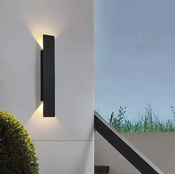 Sfeervolle verlichting van de StormGlow lamp aan een buitenmuur.