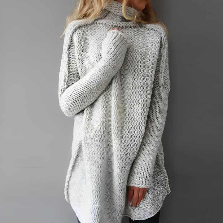 Lange gebreide damestrui met warme colkraag in grijs. Comfortabele winterkleding met losse pasvorm.