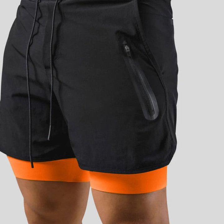 "2-in-1 sportbroek voor heren, blauw, met shorts en geïntegreerde zwarte compressielegging voor comfort en ondersteuning."