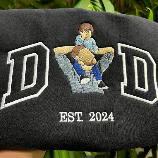 Detailopname van het strakke machinale borduurwerk op een donkere hoodie
