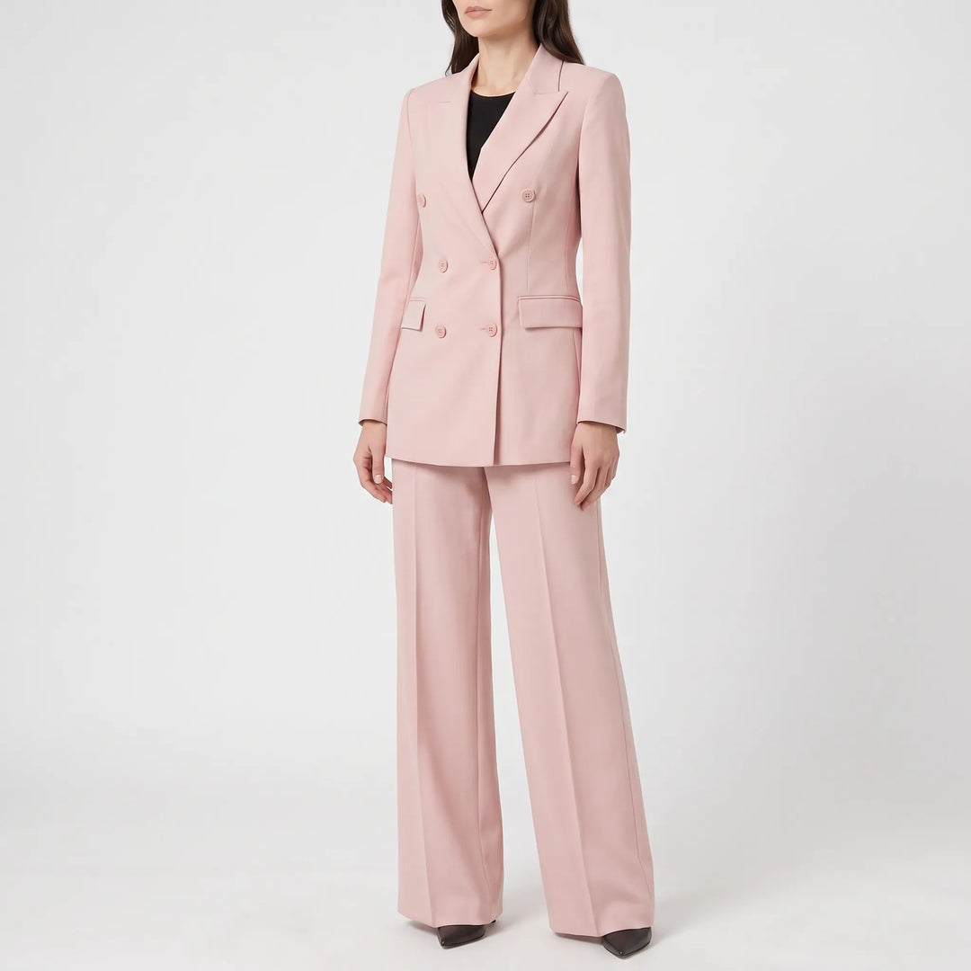 Stijlvol roze dames broekpak gedragen door een model, compleet met blazer en pantalon.