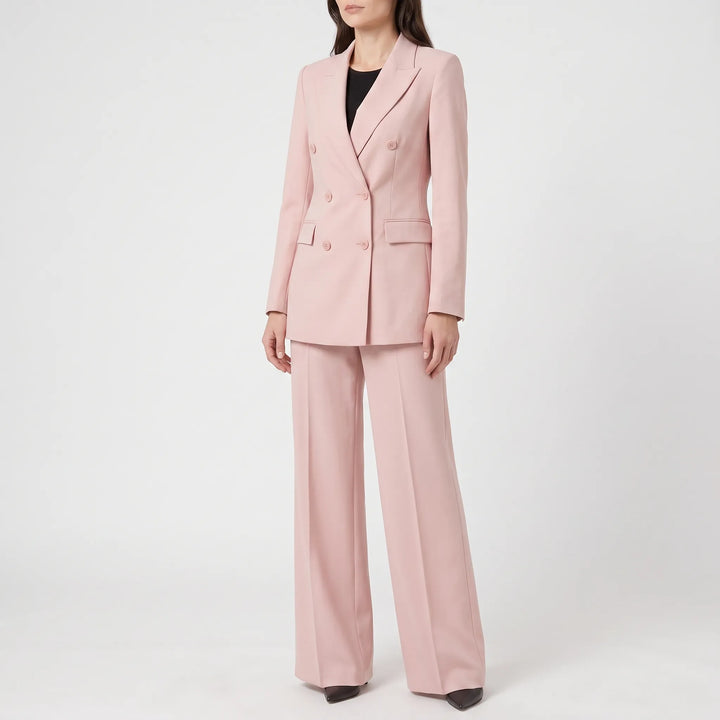 Stijlvol roze dames broekpak gedragen door een model, compleet met blazer en pantalon.
