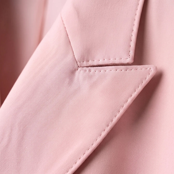 Close-up van de puntrevers en double-breasted knoopsluiting van het roze colbert.