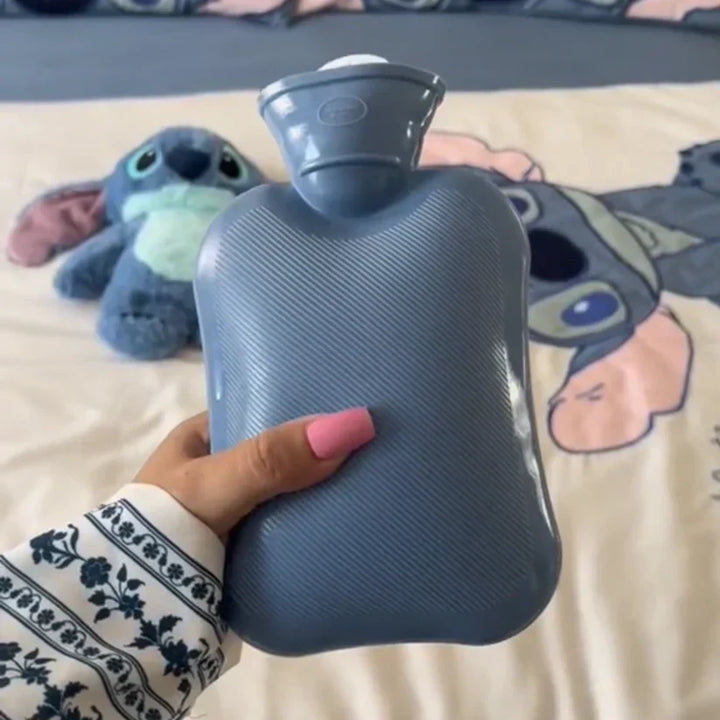Blauwe geribbelde warmwaterkruik naast een knuffel