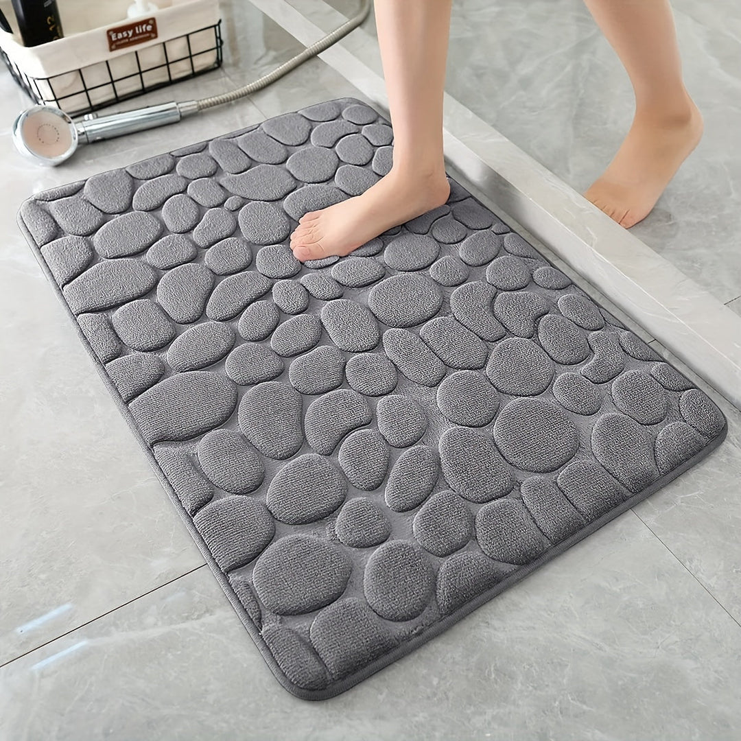 Grijze absorberende antislip badmat op een tegelvloer in de badkamer