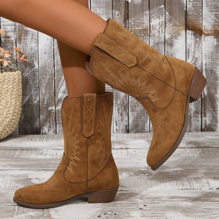 Dames cowboy enkellaarzen bruin met subtiele borduursels, gedragen op houten vloer.