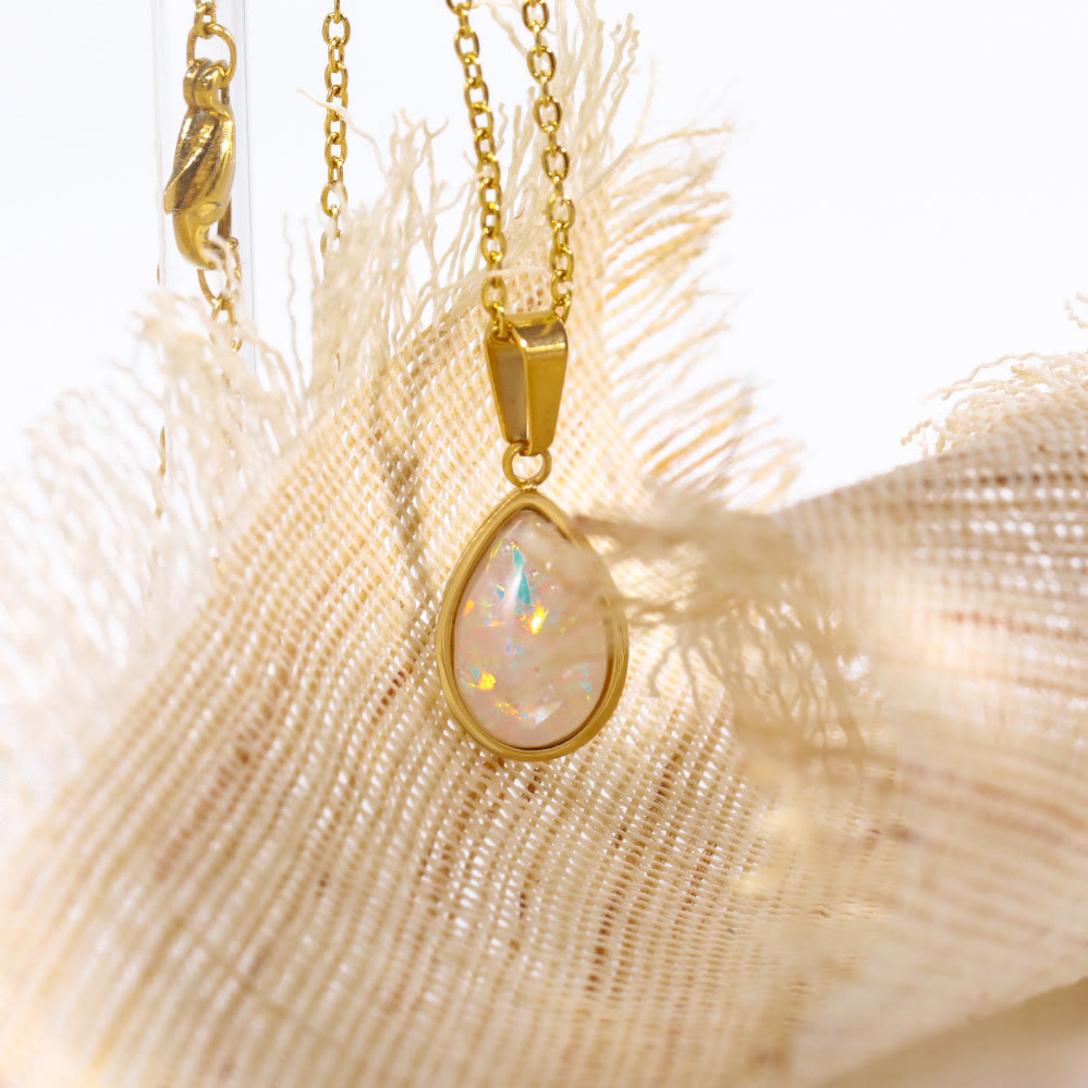 Druppelvormige opaal hanger aan een 18K gouden ketting, een elegant dames sieraad.