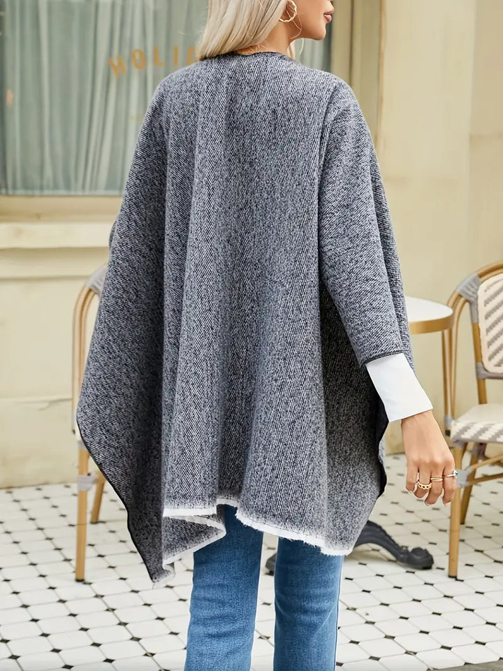 Vrouw draagt een stijlvolle retro damesponcho van zachte kasjmierlook, comfortabel en loose fit.