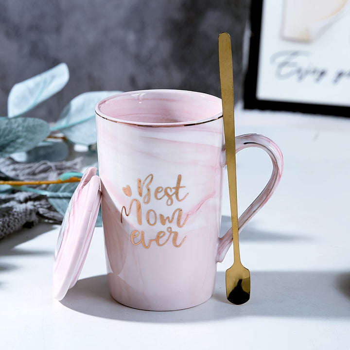 Detailopname van de roze marmeren mok met gouden lepel en deksel