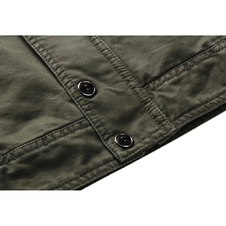 Heren outdoorjas militairgroen, gecombineerd met jeans voor een casual, comfortabele look. Veelzijdige seizoensjas.