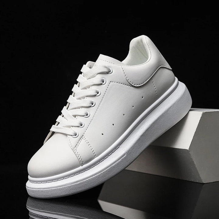 Stijlvolle witte heren sneakers gepresenteerd op een modern blok