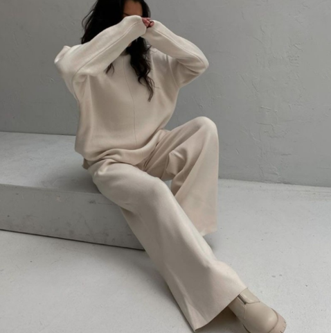Vrouw zit in een comfortabel beige dames huispak