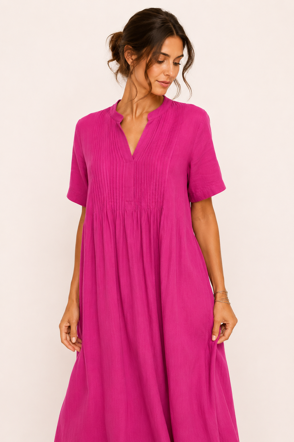 Close-up van de plooien en V-hals van de roze maxi-jurk