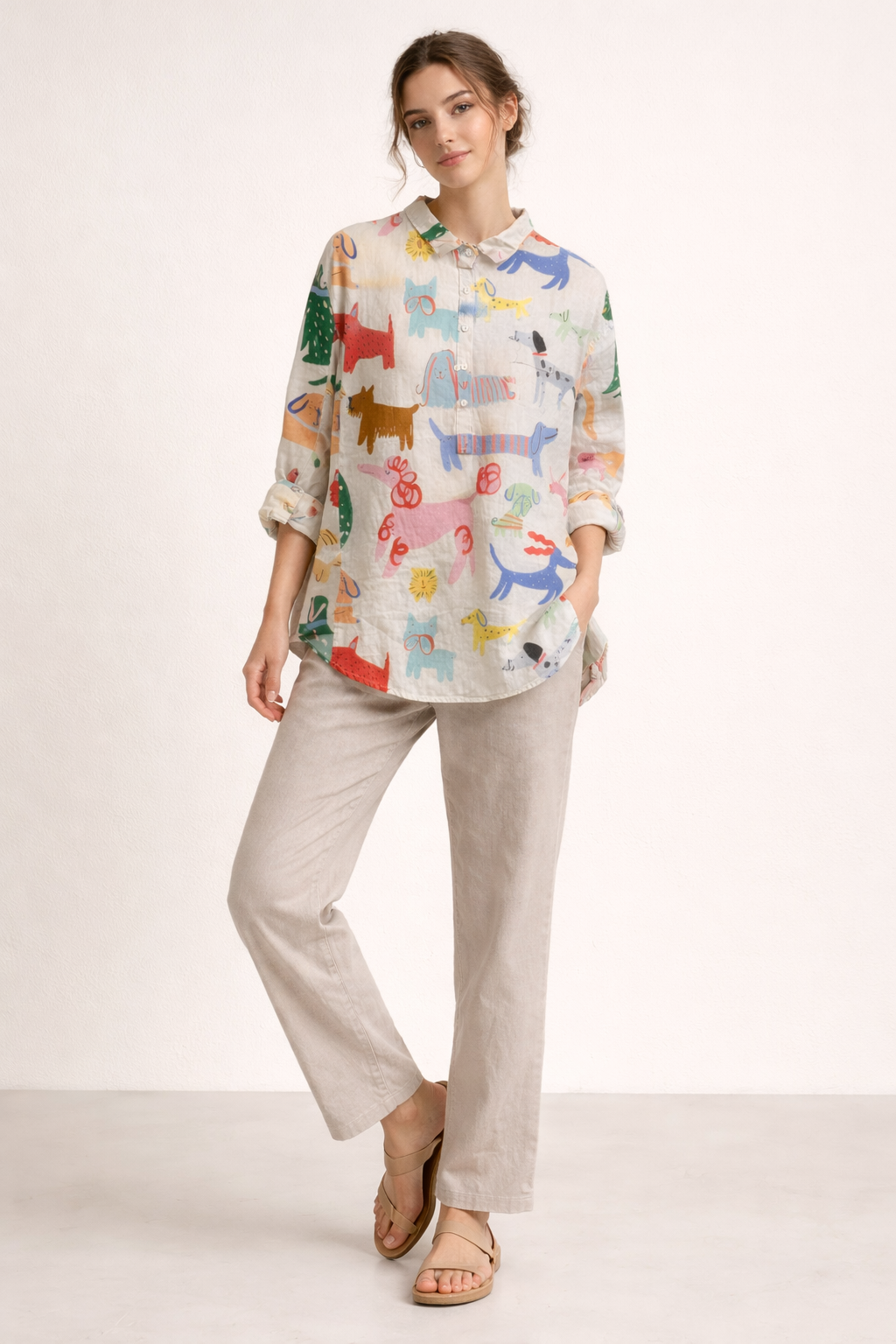 Volledige look van model met witte blouse met dierenprint, comfortabele broek en sandalen.