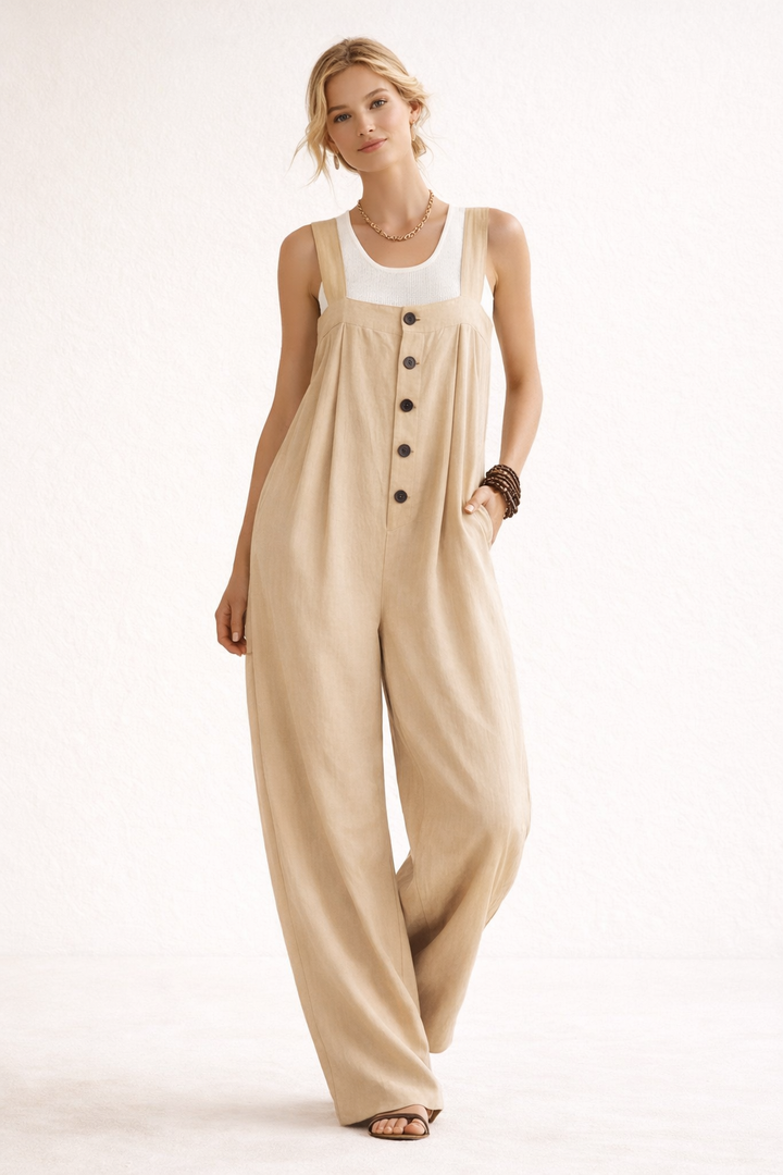 Model draagt de beige variant van de lange jumpsuit met knoopsluiting