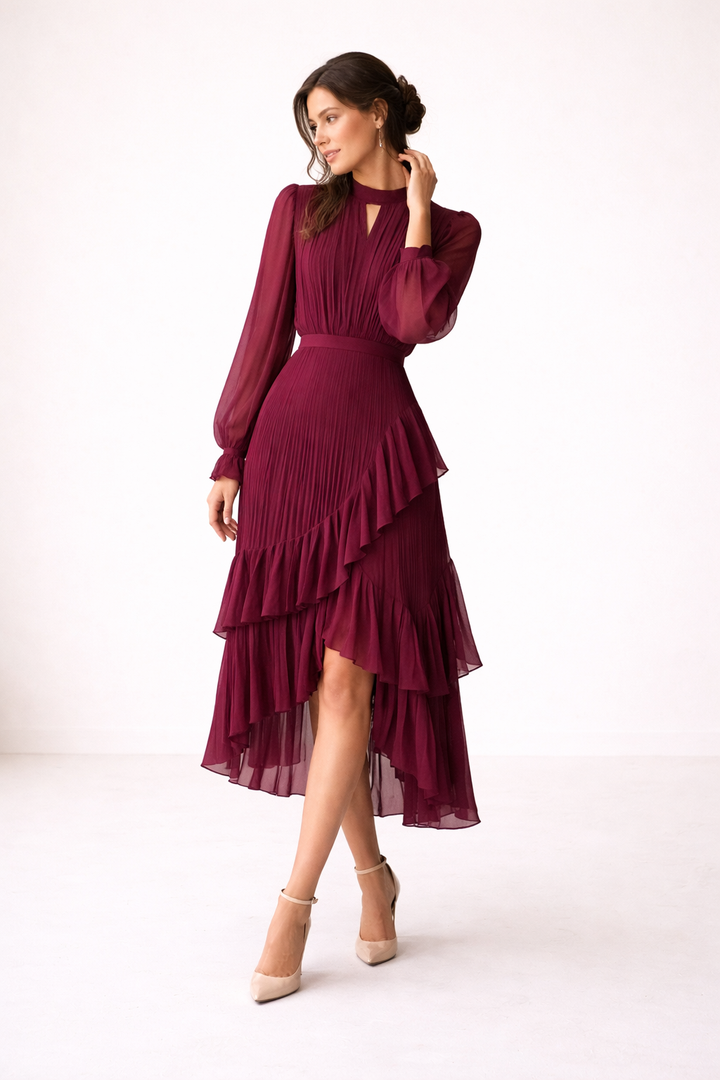 Model draagt elegante rode plissé midi-jurk met lange mouwen