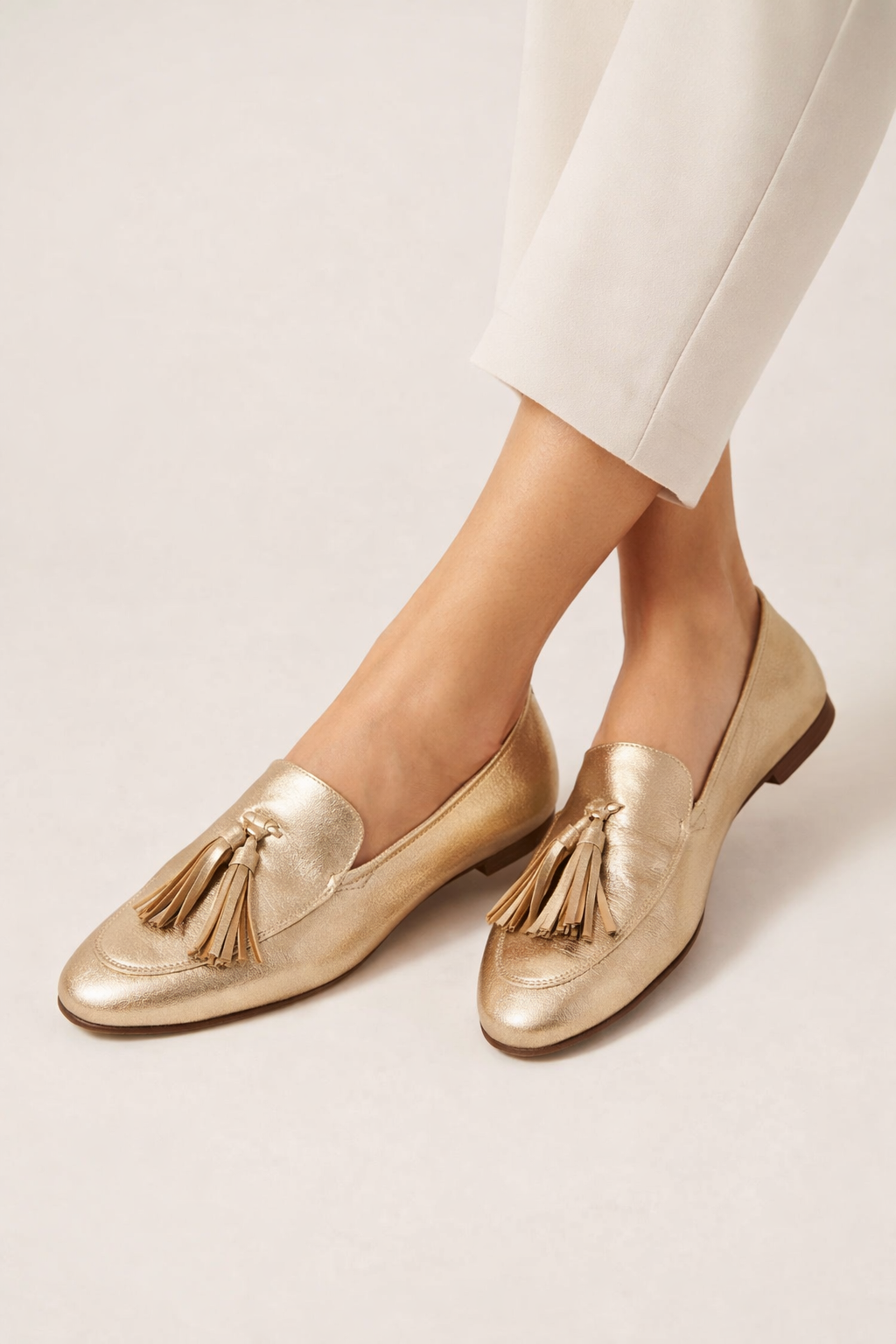 Close-up van de gouden instapschoenen met elegante kwastdetails