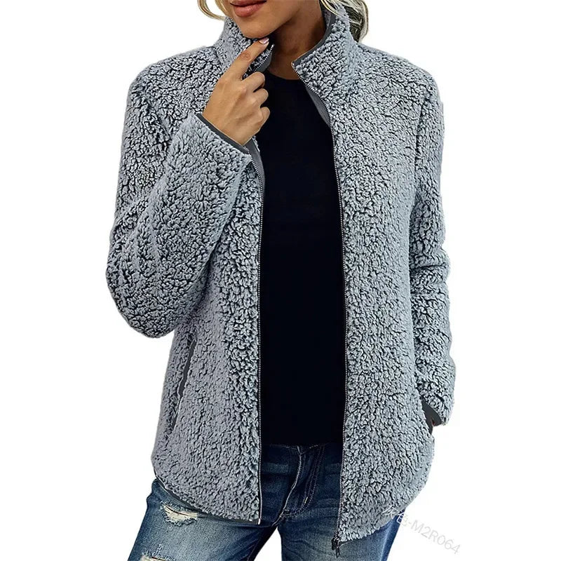 Detailopname van de ritssluiting en zachte textuur van de beige teddy jas
