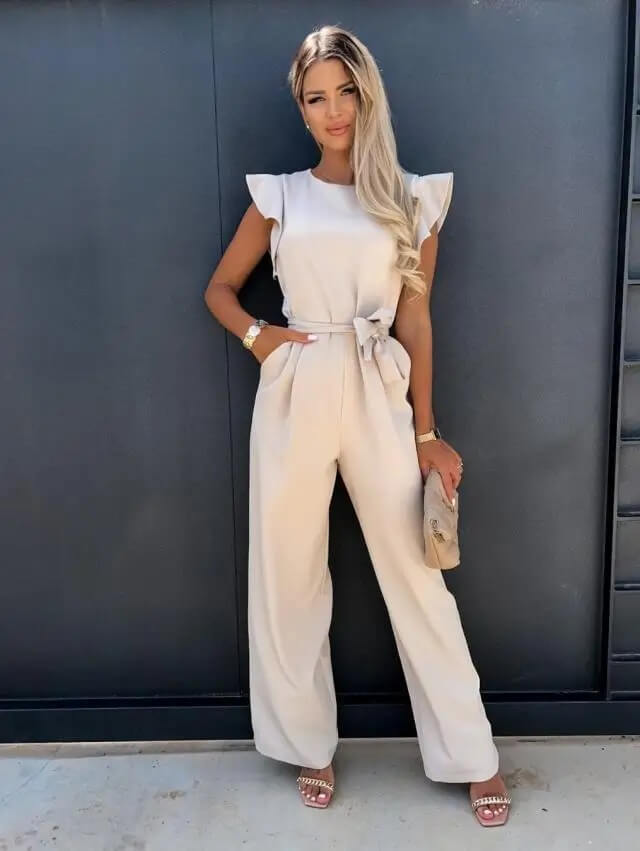 Vrouwelijke beige feestelijke jumpsuit met wijde pijpen en strikceintuur