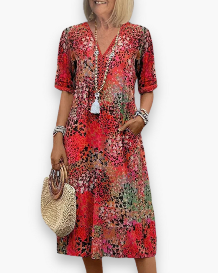 Dames midi-jurk met levendige bloemenprint, V-hals en zakken voor een casual zomerlook. Comfortabel en elegant.