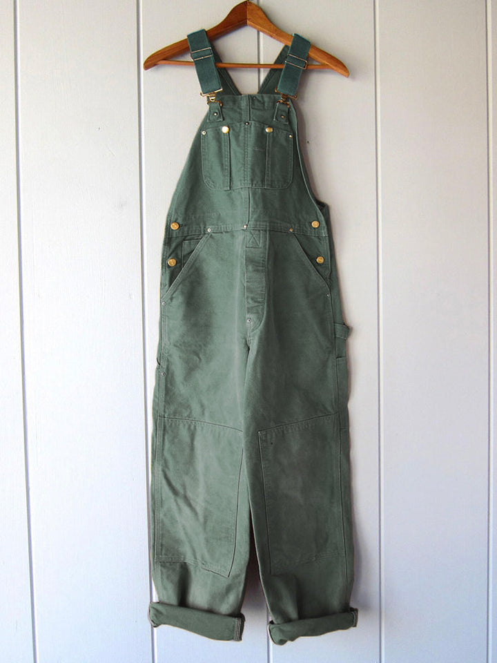 Detail van praktische zakken op een robuuste canvas werkoverall, ideaal voor gereedschap. Unisex model.