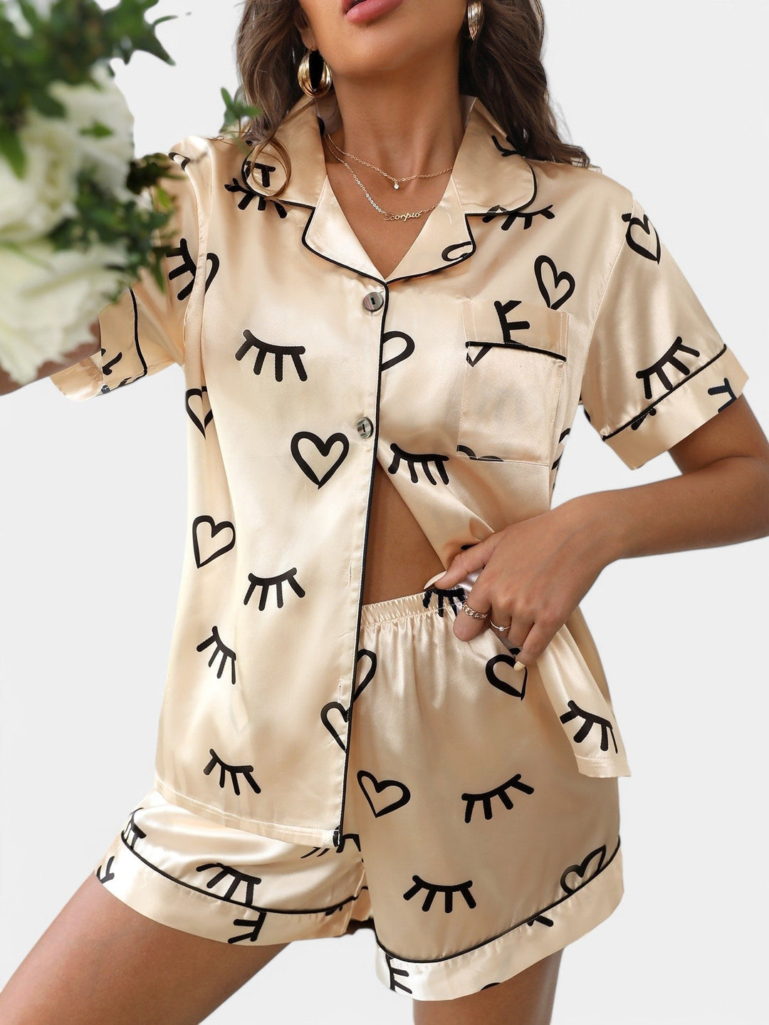 Vrouw in champagnekleurige satijnen pyjamaset met print