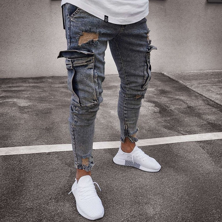 Man draagt donkerblauwe cargo broek met witte sneakers