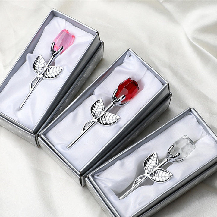 Drie kristallen rozen in verschillende kleuren gepresenteerd in open geschenkdozen