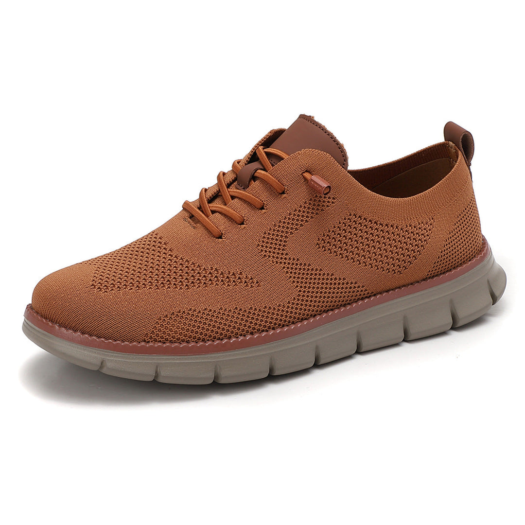 Karamelkleurige herenschoenen met ademend bovenwerk op een egale achtergrond