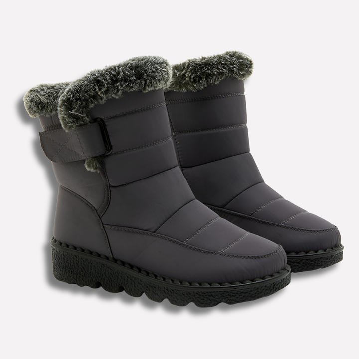 Grijs zwarte waterdichte winterlaarzen voor dames in de sneeuw