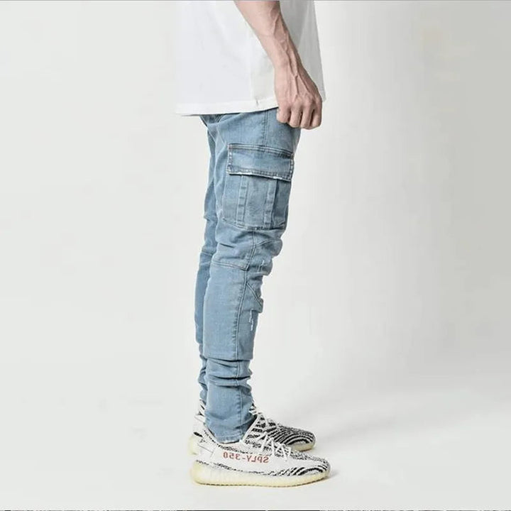 Zijkant van de blauwe cargobroek voor heren gecombineerd met sneakers