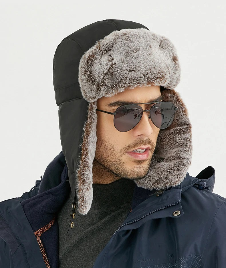 Stijlvolle man draagt zwarte alpine muts met bontrand en oorkleppen, perfect voor winterse avonturen
