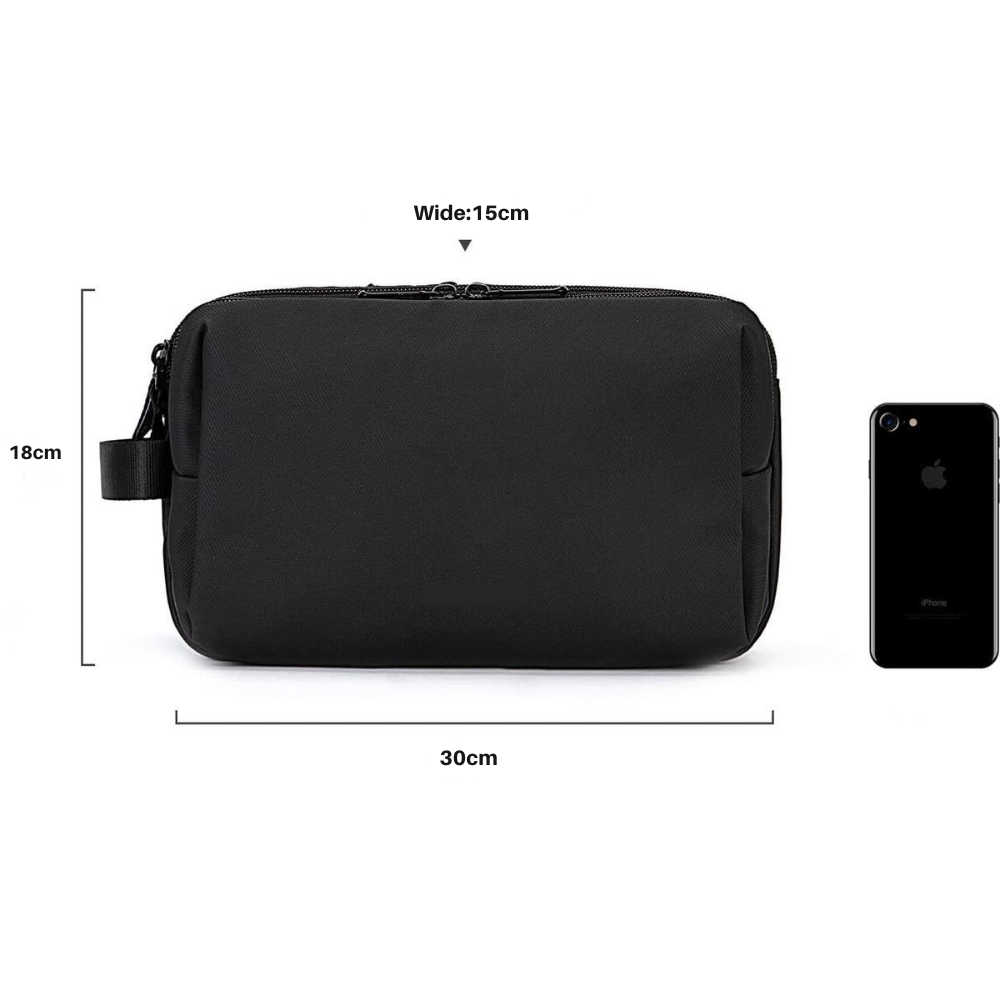 Zwarte reistoilettas voor heren met afmetingen van 30 cm breed, 15 cm diep en 18 cm hoog naast een smartphone