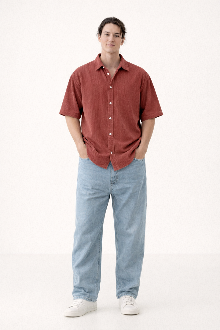 Volledige foto van een man in een rood casual zomers overhemd met korte mouw en witte sneakers