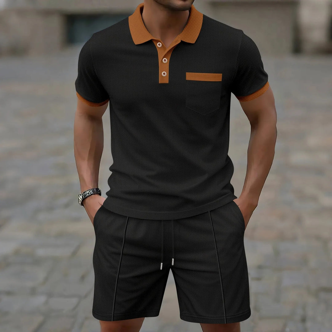 Man draagt zwarte heren polo set met korte broek en contrasterende kraag