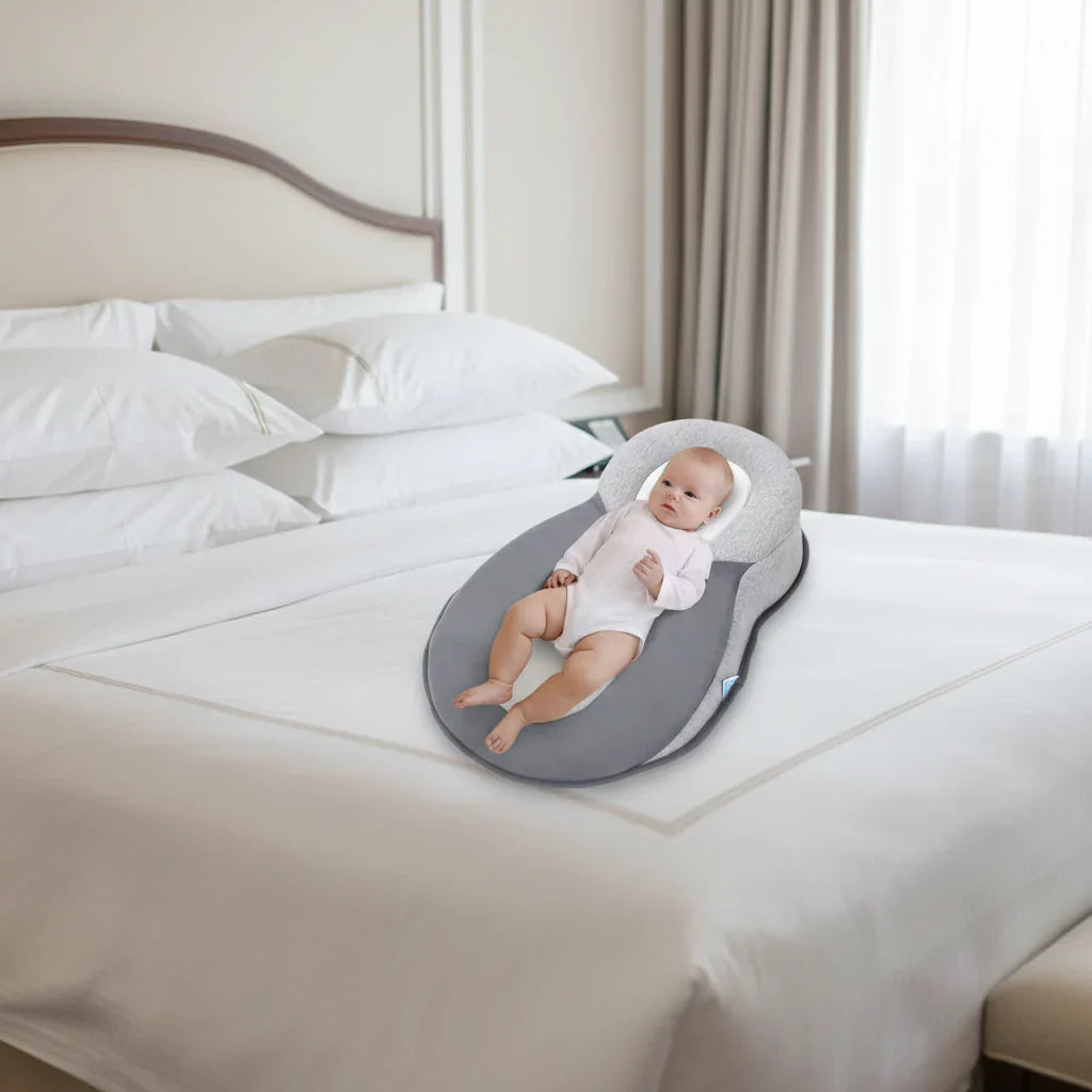 Baby ligt comfortabel en veilig op het Nap Baby Kussen in een ledikant.