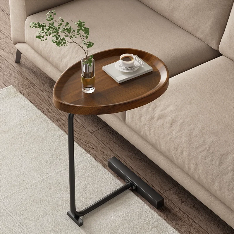 Stijlvolle houten bijzettafel naast een moderne beige bank in de woonkamer