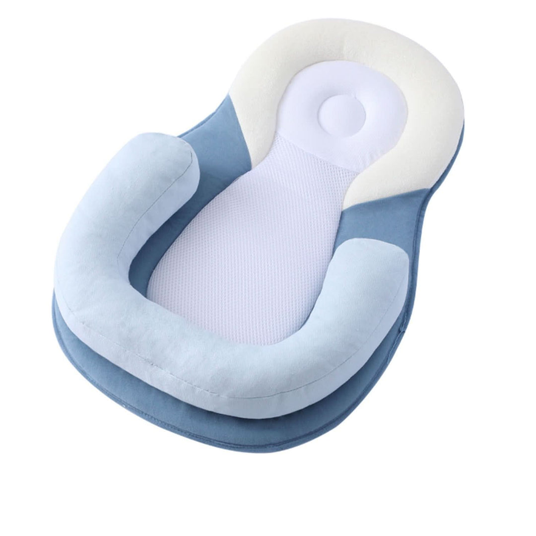 Baby ligt rustig te slapen, omringd door het kussen, op een kinderbed.