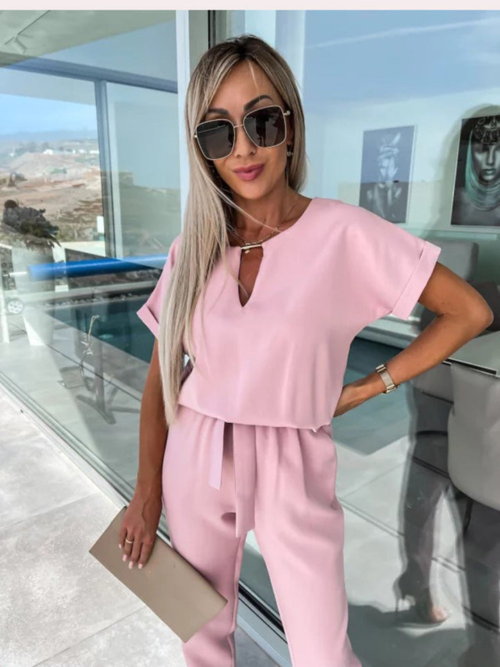 Zomerse dames jumpsuit, elegant en veelzijdig. Kenmerkt zich door een V-hals en chique geplooide korte mouwen.