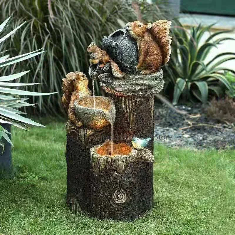 Volledige weergave van een solar fontein met eekhoorns en stromend water in een tuin.