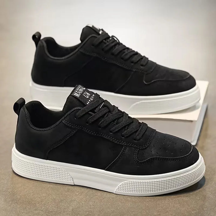 Zijdezicht op zwarte heren sneakers op ondergrond
