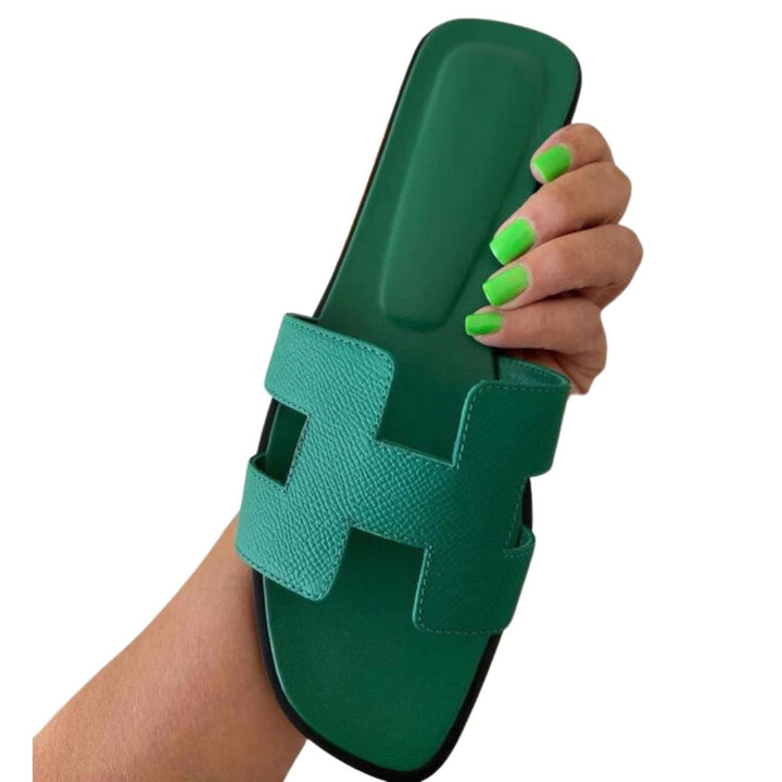Groene stijlvolle damessandalen in de hand