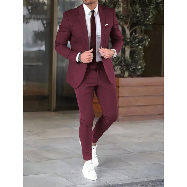Man in bordeauxrood/rood modern slim fit maatpak met wit overhemd en stropdas