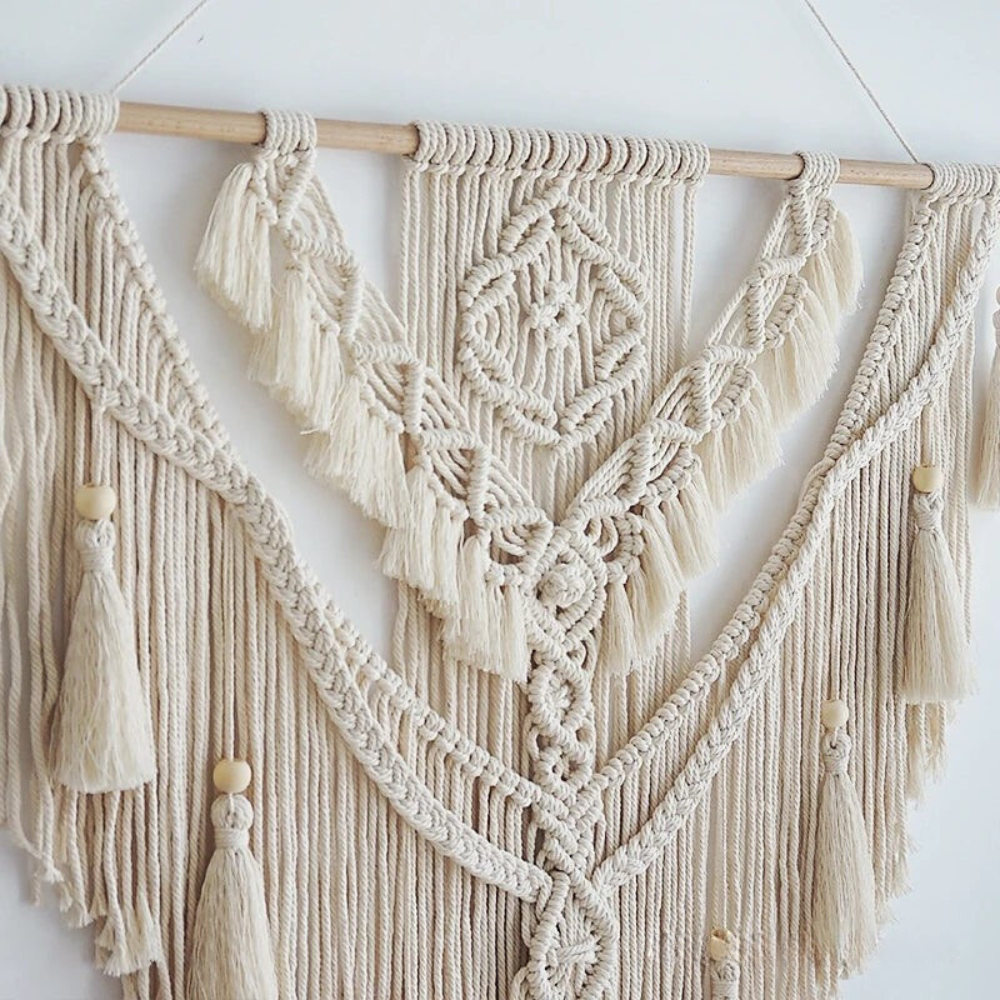 Close-up van het verfijnde knoopwerk en houten kralen van de macramé wandhanger
