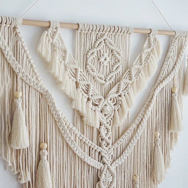 Close-up van het verfijnde knoopwerk en houten kralen van de macramé wandhanger