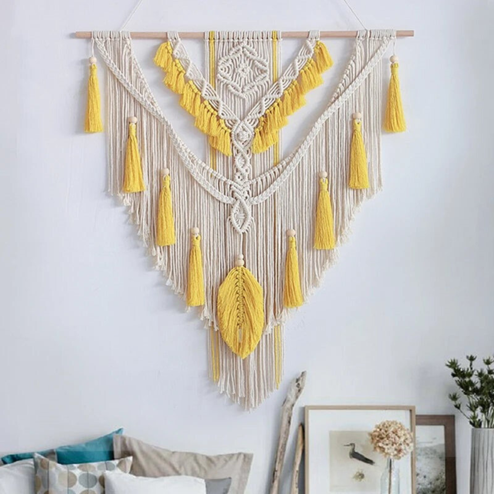 Gele en beige macramé wandhanger als sfeervolle wanddecoratie boven een bed