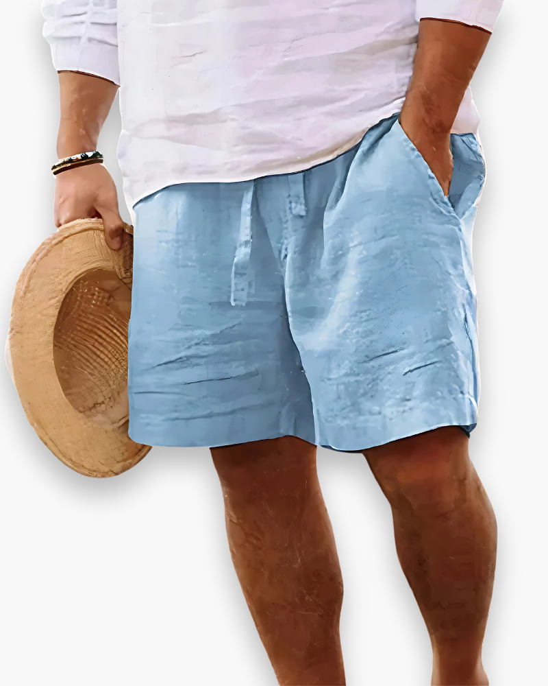 Man met lichtblauwe zomershort en strohoed, comfortabele stijl.